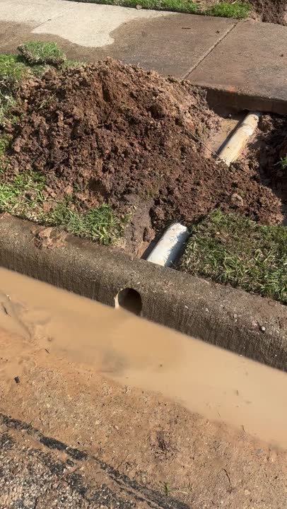 Finished Waterline drainage job: cored curb with white PVC daylight pipes discharging captured stormwater into the gutter
